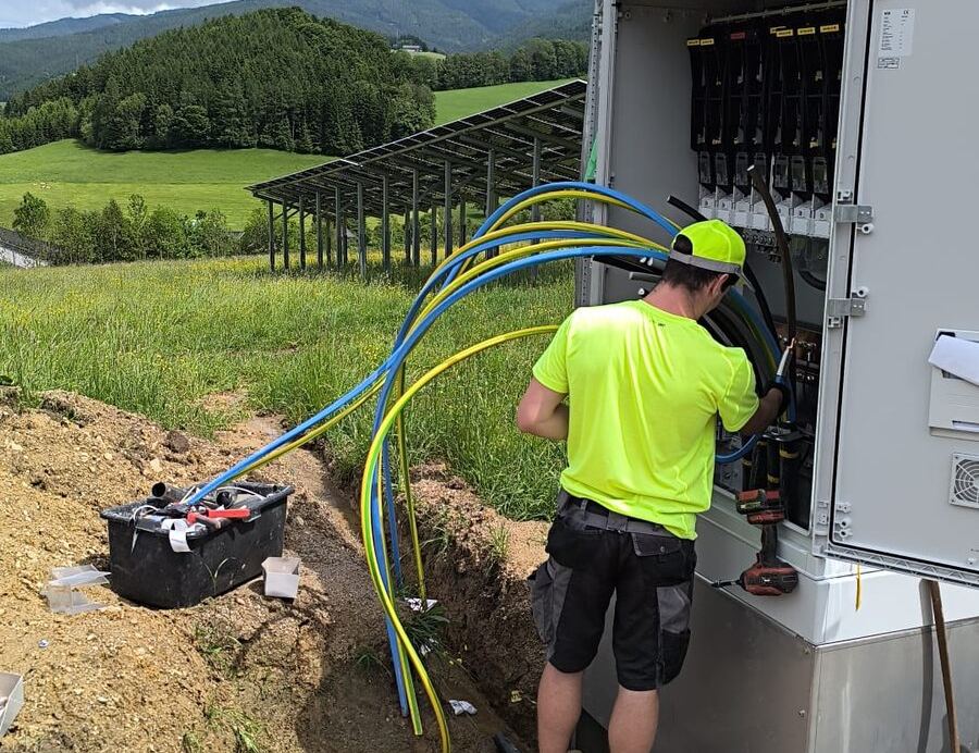 Techniker von C-Tek beim Anschluss des Verteilers einer Freiflächen-Photovoltaikanlage